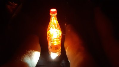 Eine Flasche wird von unten beleuchtet, dadurch entsteht ein warmes Licht